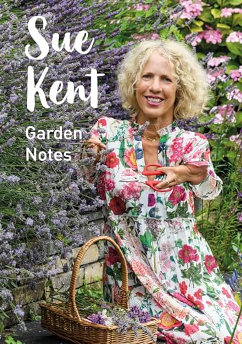 A smiling woman in a floral dress holds pruning shears beside a lavender bush.