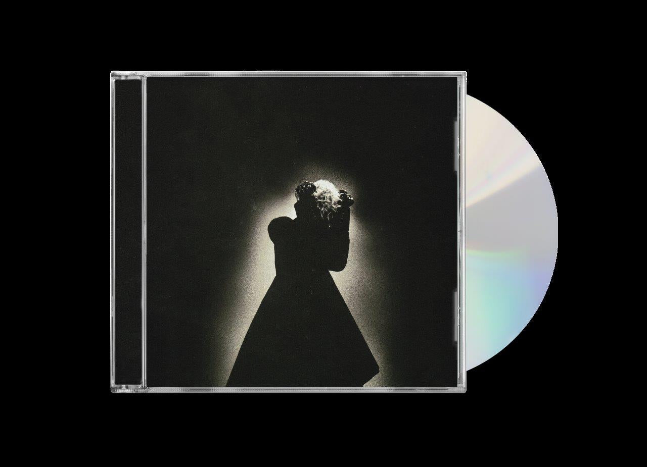 CD case with a silhouetted figure holding flowers against a dark background.