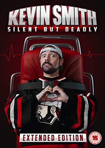 Kevin Smith on a stretcher, making a heart shape with his hands.