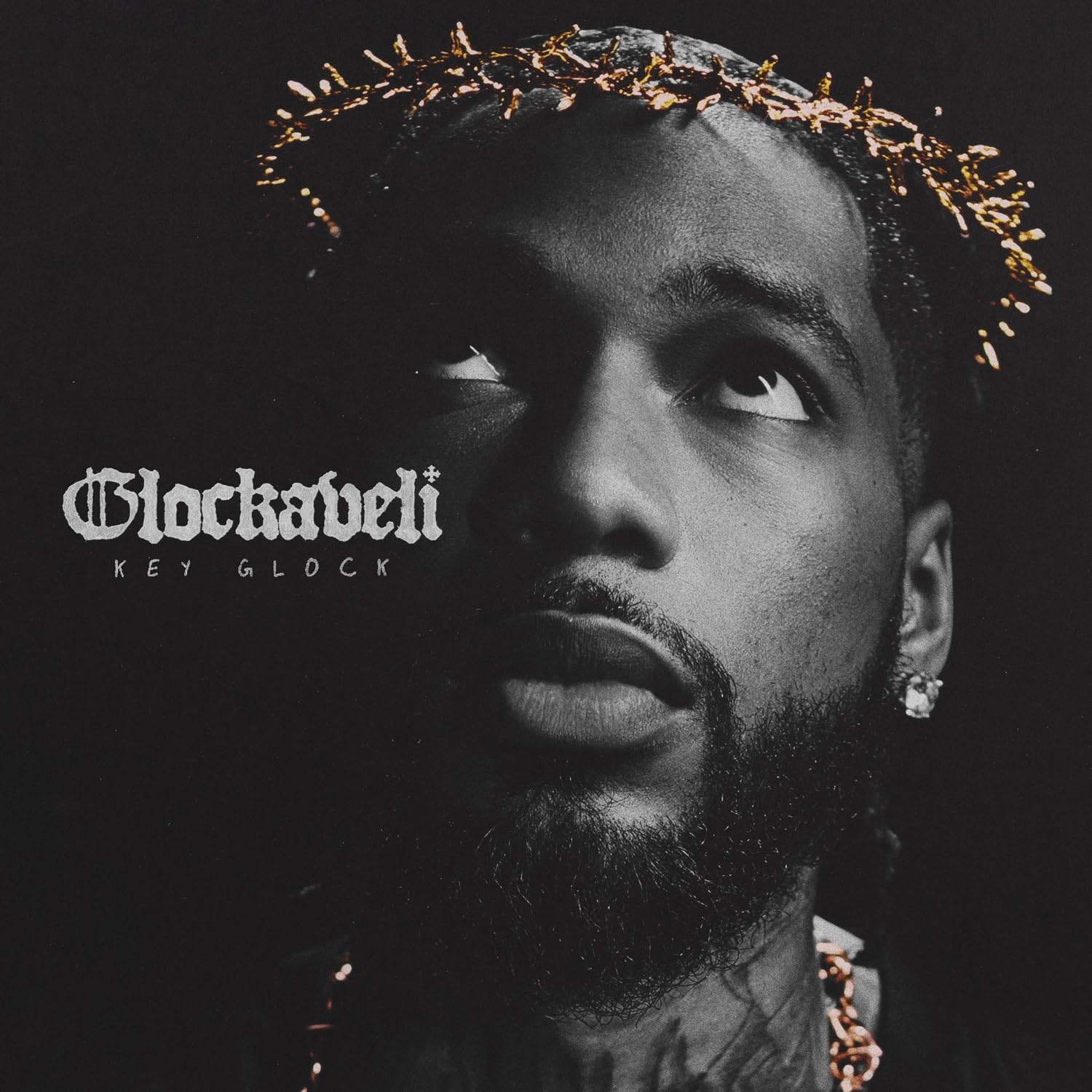 Key Glock album cover: close-up of rapper with thorn crown, dark background.