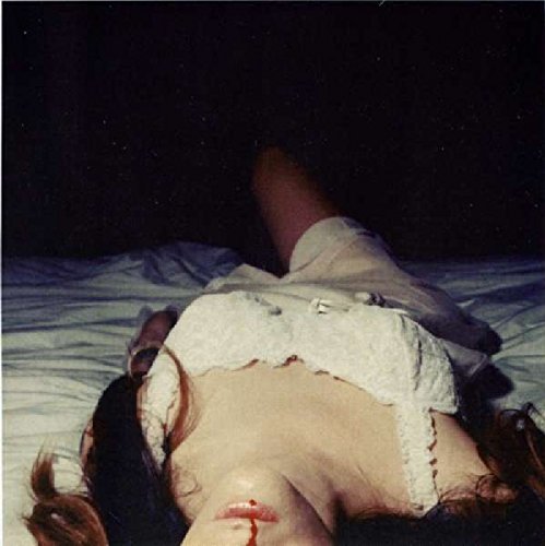 A vinyl record cover featuring a woman lying on a bed, bleeding from her mouth.