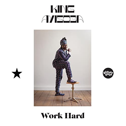 King Ayisoba in patterned suit seated on stool, album cover.