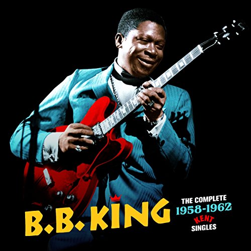B.B. King playing a red electric guitar on a black background.