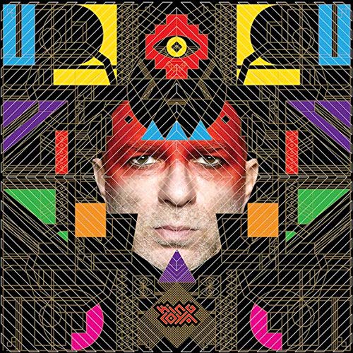 A man's face with red makeup centered within complex, colorful geometric patterns on black.