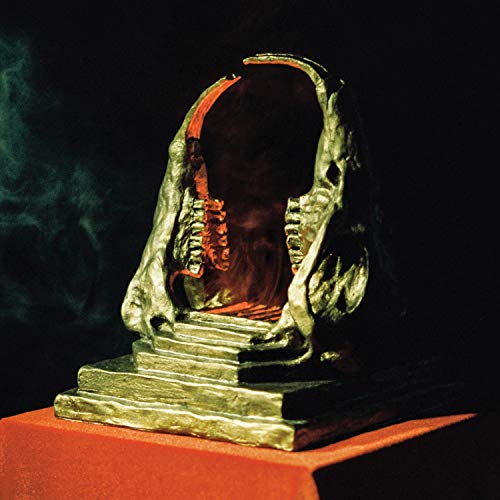 Album cover: a monstrous, tooth-filled maw atop stone steps, red background.