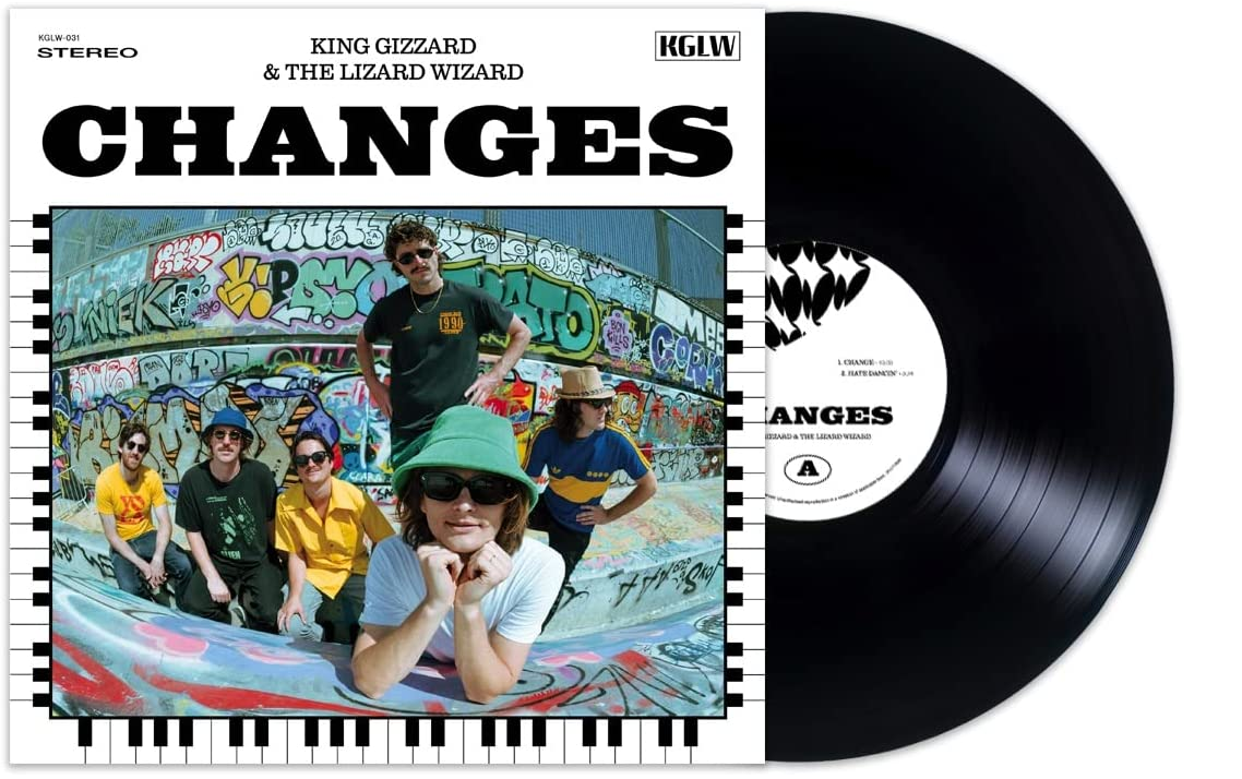 "Black vinyl record with white label next to album cover featuring five men posing."