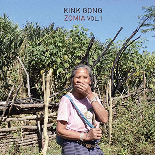 Vinyl album cover: woman in a field with rustic wooden structures.