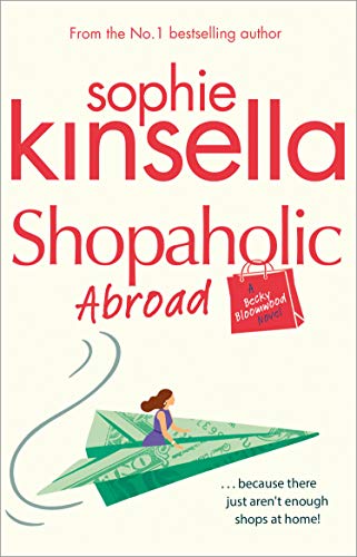 Book cover: “Shopaholic Abroad” with a paper airplane and shopping bag.