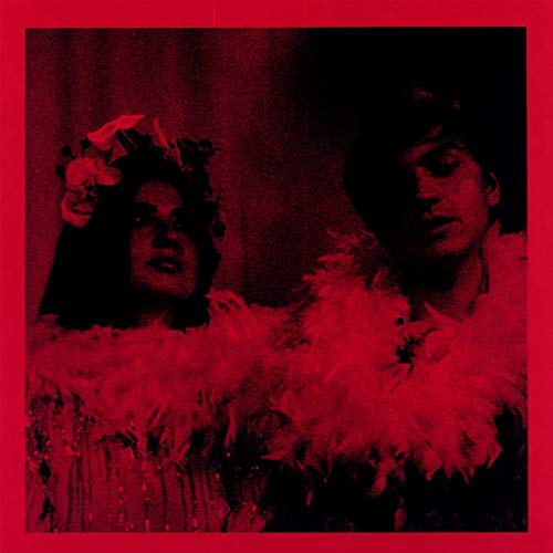 Red album cover featuring two people with feather boas and floral headwear.
