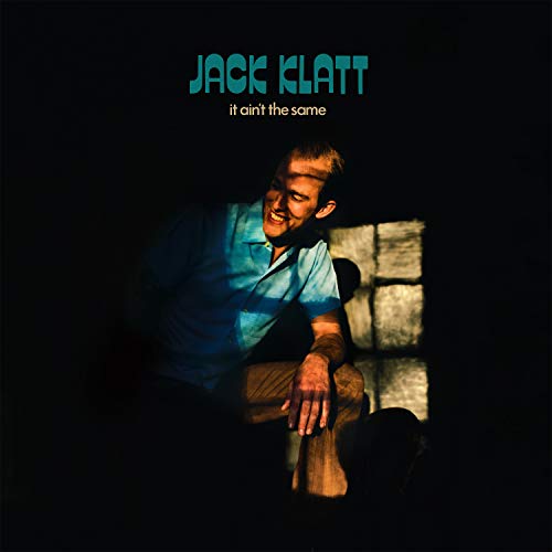 "Album cover featuring a man sitting on a bench, with artist name and title."