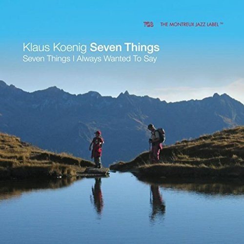 "Album cover featuring two hikers near a lake with mountains in the background."