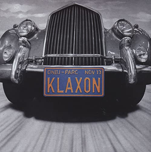 Vintage car grille with “Klaxon” license plate, grayscale image.