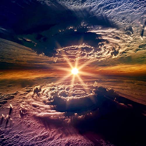 A bright sun shines between two swirling cloud formations in a dramatic sky.