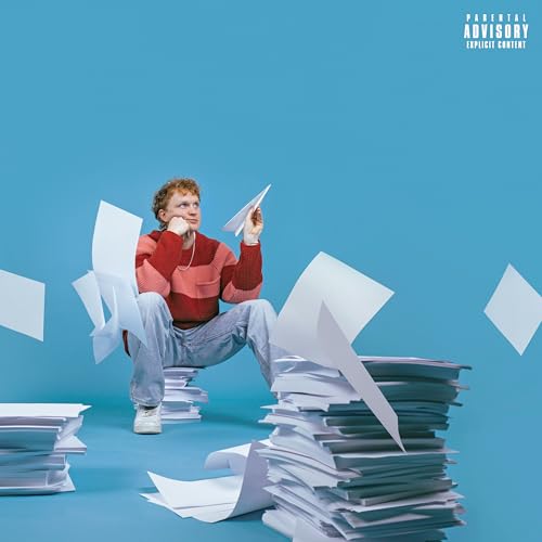 Young man with red hair launching a paper airplane amid papers.