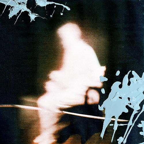 Blurred figure with paint splatters on a dark background.