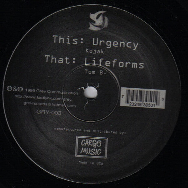 Black vinyl record label with white text: "Kojak/Tom B. - Urgency/Lifeforms.
