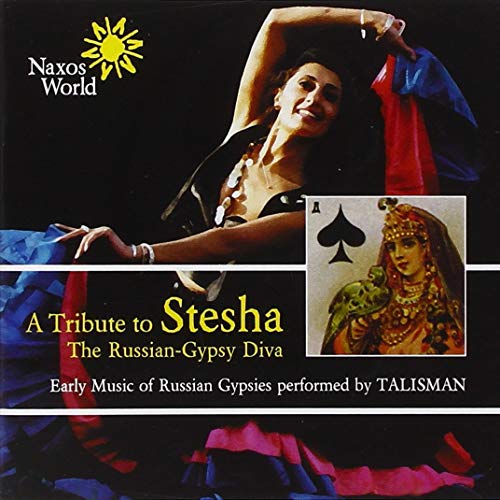 A woman in a black dress dances next to an image of a playing card.