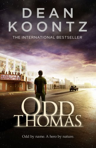 A man stands on a street in front of the Rialto theater at sunset.
