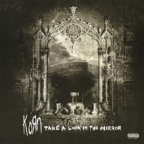 Ornate, gothic mirror reflecting a dark landscape, Korn album cover.