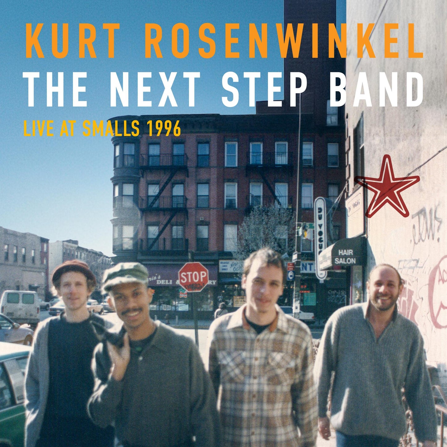 Kurt Rosenwinkel band photo with city street and buildings backdrop.