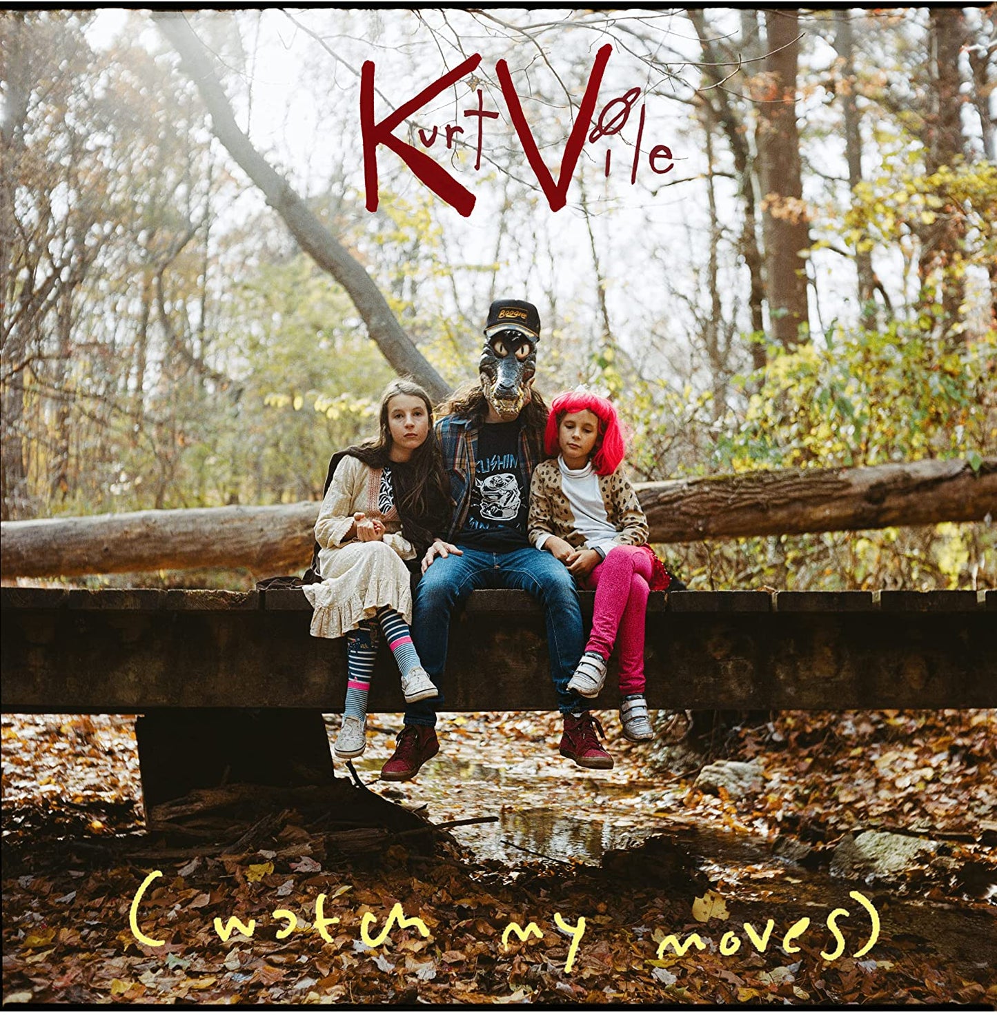 Kurt Vile album cover: three people sitting on a log in the woods.
