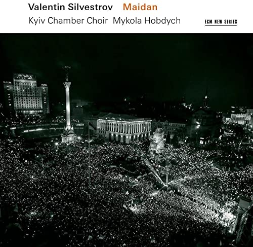 CD cover: Nighttime cityscape with a large crowd and central monument.