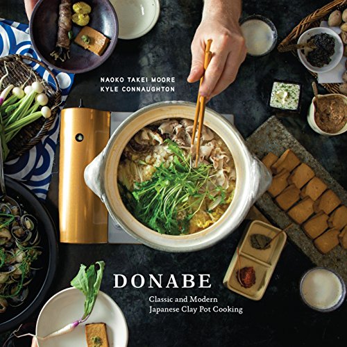 Top-down view of a Japanese clay pot with ingredients and chopsticks on a table.