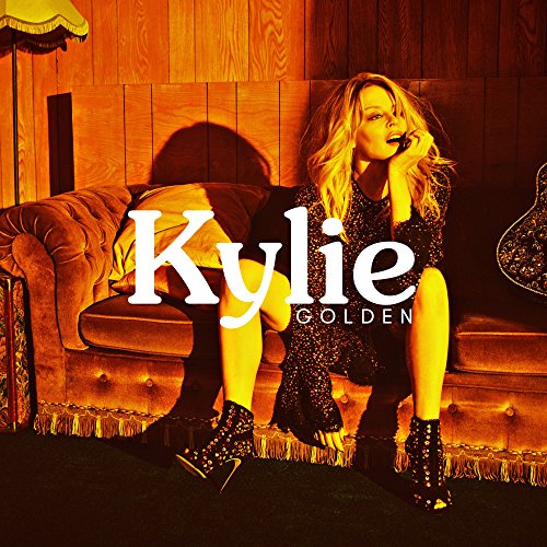 "Kylie Minogue sitting on a couch, wearing a sparkly dress and boots, with 'Kylie Golden' text."