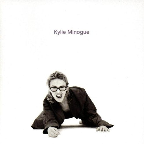 Black and white album cover featuring Kylie Minogue in a suit crawling forward.
