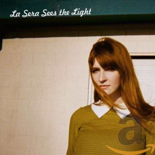CD cover: woman with long hair against a textured wall.