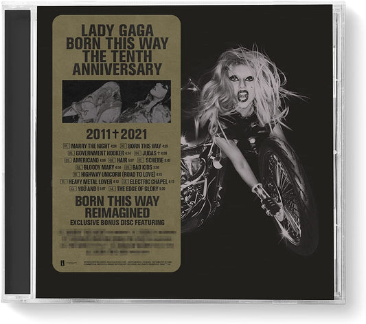 Lady Gaga with long blonde hair riding a motorcycle against a black background.