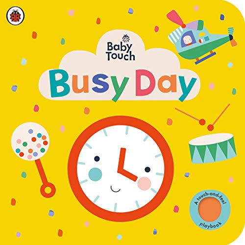 Bright yellow baby book cover with a clock, rattle, and airplane.