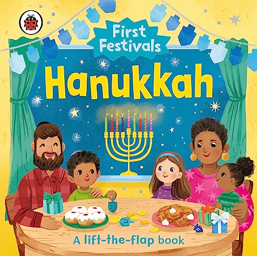 A family sits at a table with a menorah, sufganiyot, and dreidels for Hanukkah.