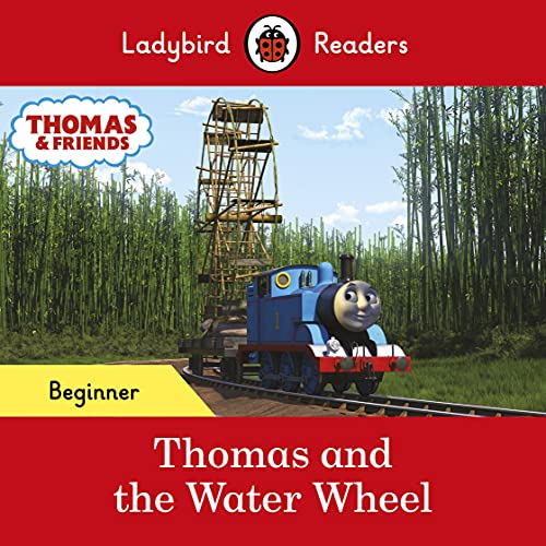 Blue train Thomas travels past a large wooden water wheel in greenery.