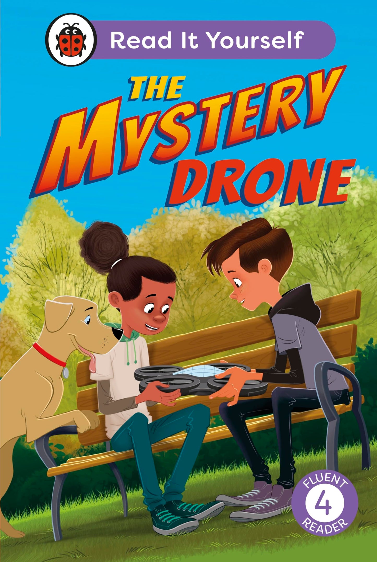 A boy, girl, and dog sit on a park bench examining a small drone.