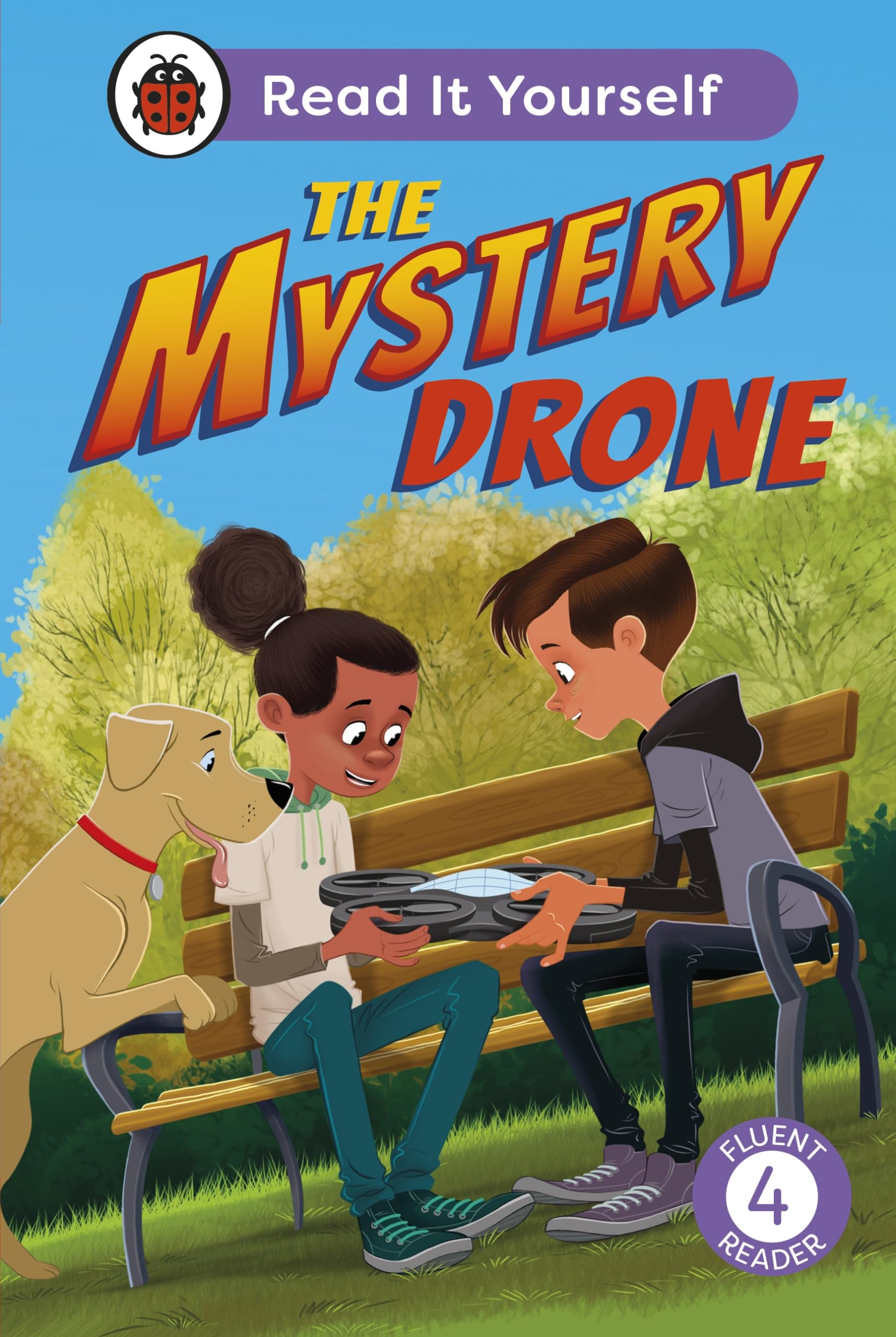 A boy, girl, and dog sit on a park bench examining a small drone.
