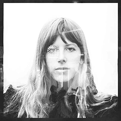Black and white portrait of a woman with patterned eyes, looking forward.