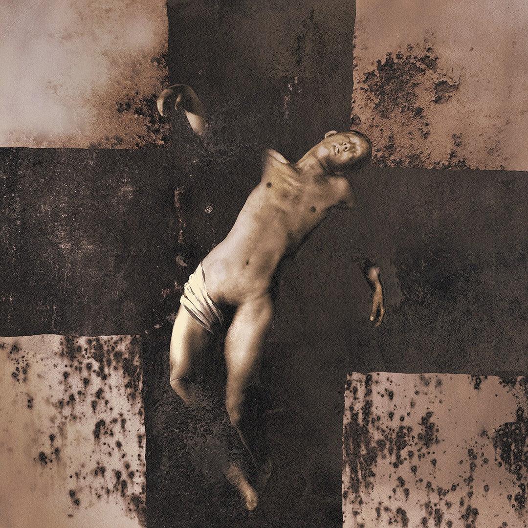 Nude figure lying on a cross-shaped, textured, monochrome background.