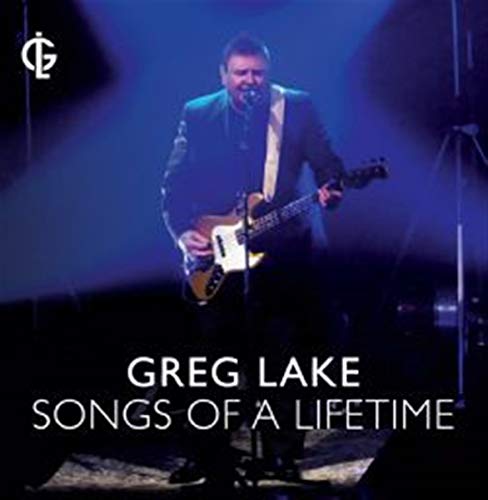 Greg Lake performing on stage with a bass guitar under blue spotlights.