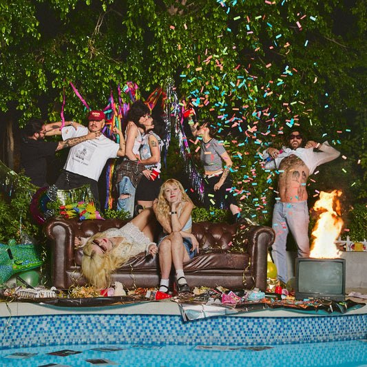 Group of people at a chaotic pool party with confetti falling.