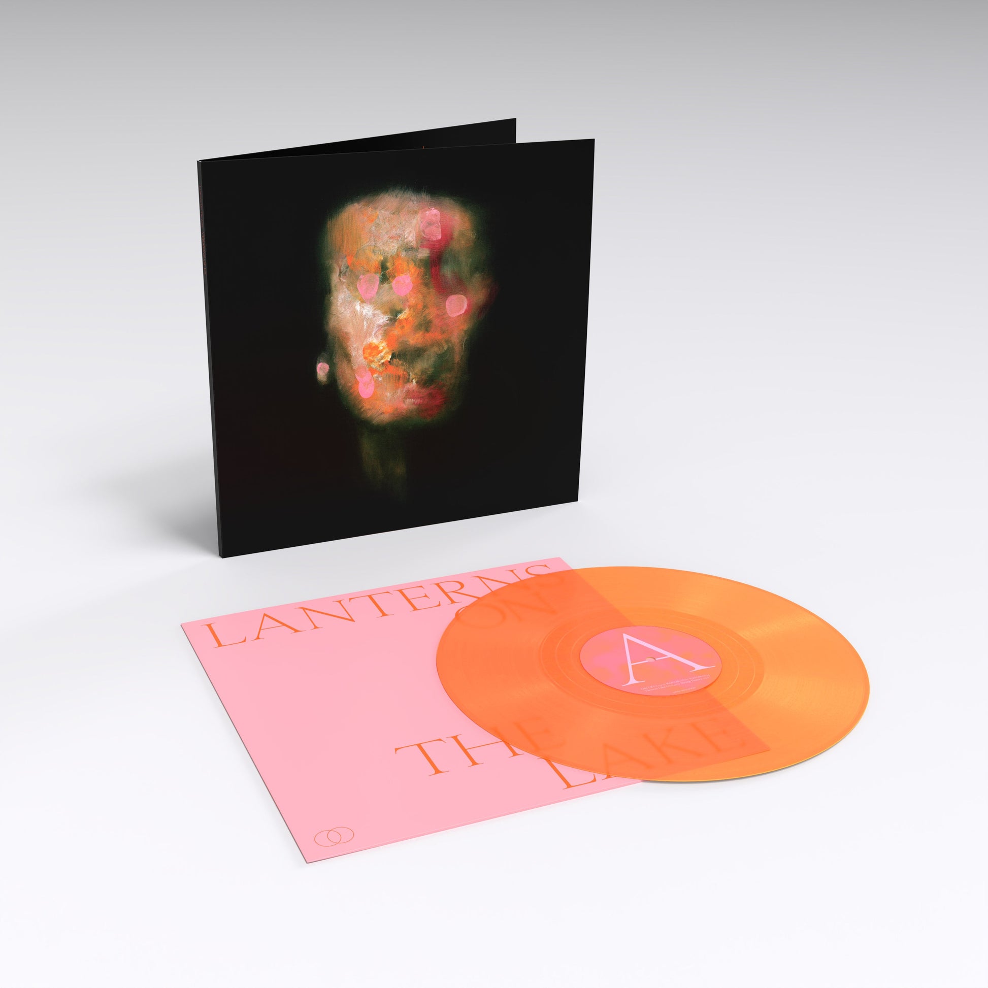 Vinyl LP with abstract portrait cover and two colored records displayed.