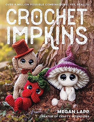 Three crocheted figures, including a strawberry-themed creature, sit near a tree trunk.