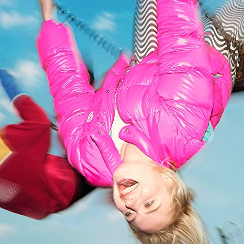 Blonde person in pink puffer jacket, viewed from below, smiling upwards.