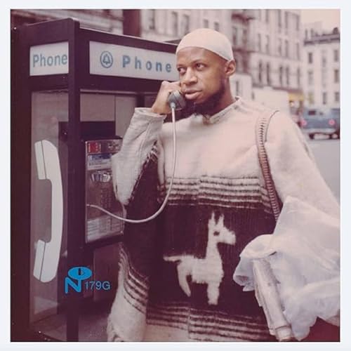 Laraaji on album cover, using a public phone in a city.