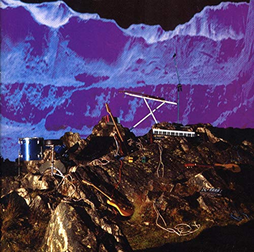 Musical instruments scattered on a rocky landscape against a purple mountain backdrop.