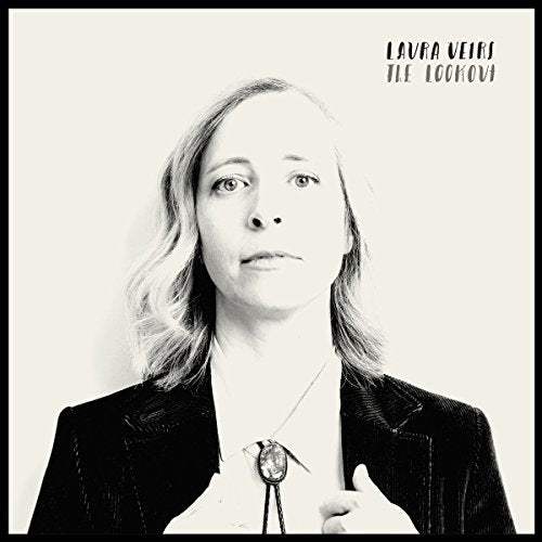 Black and white portrait of Laura Veirs wearing a bolo tie and dark jacket.