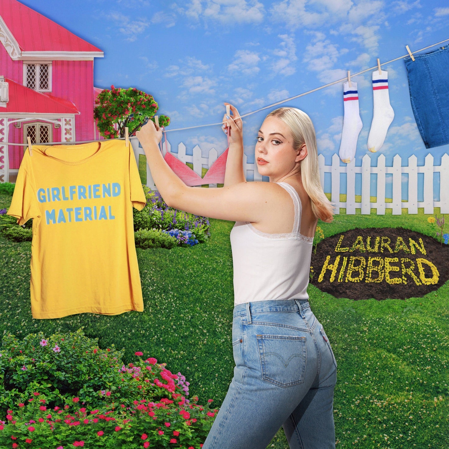Woman hanging laundry, including a yellow shirt reading "GIRLFRIEND MATERIAL".