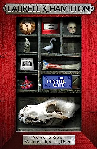 Book cover for "The Lunatic Cafe" with oddities in a cabinet.
