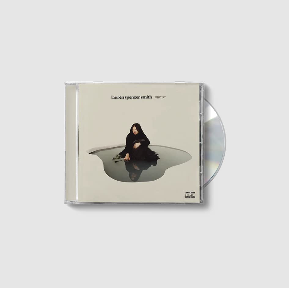 "CD case with a woman in black sitting in a puddle on the cover."