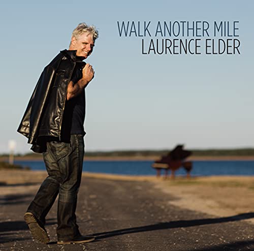 Laurence Elder album cover: man walking with a piano in the background.